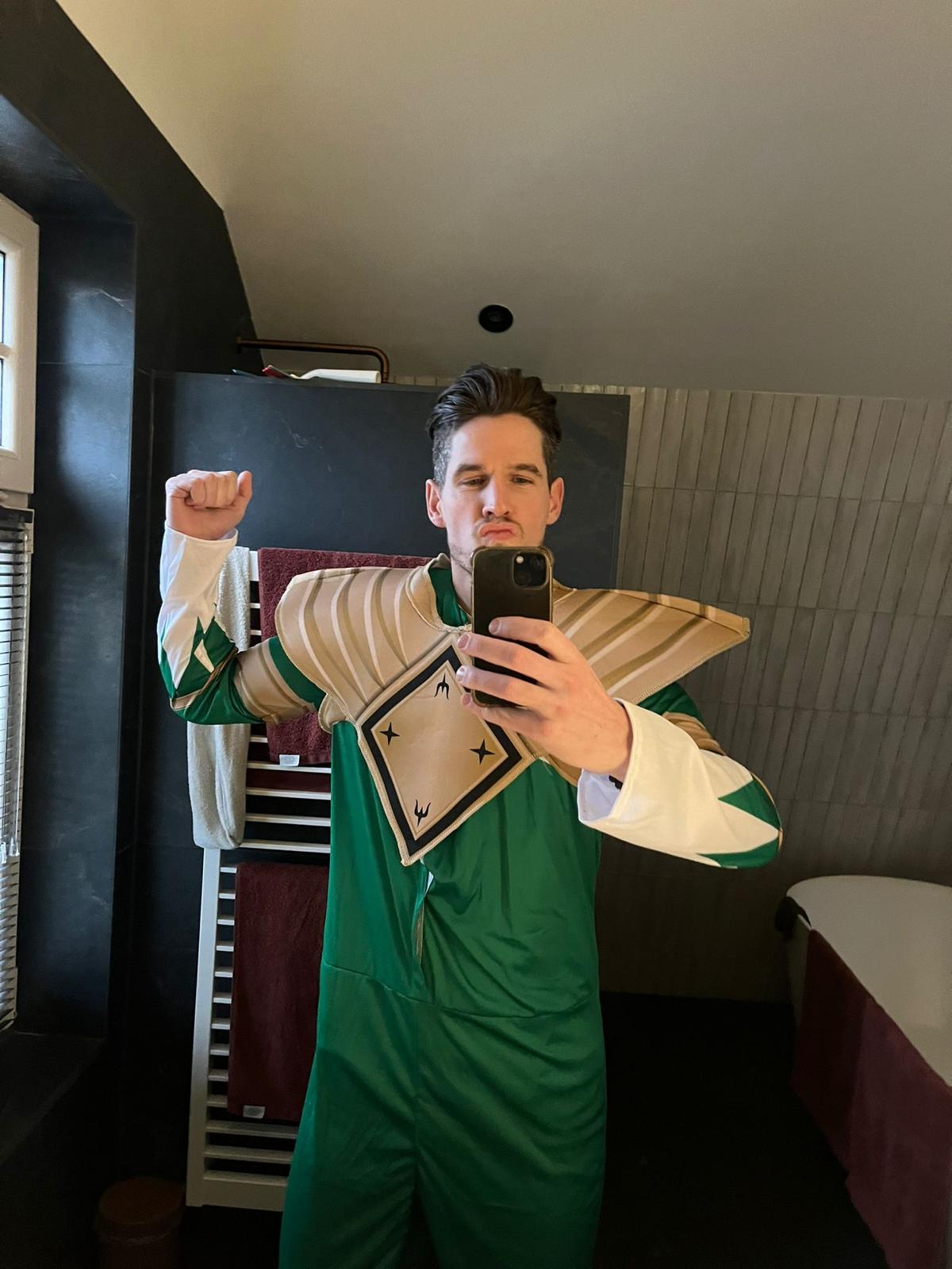 Tiemen poseert voor de spiegel in een groen fantasie-uniform